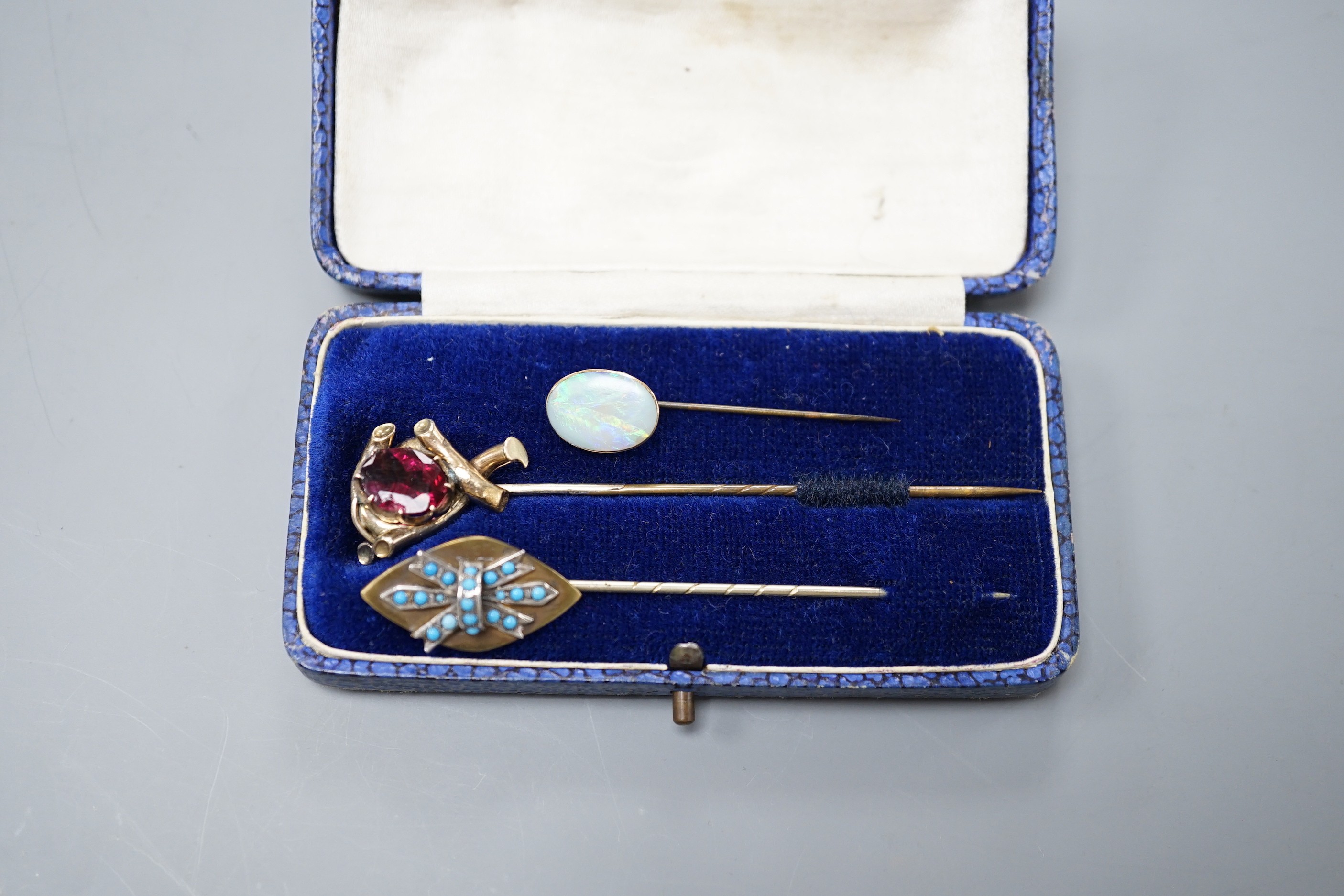 Three various base metal stick pins, one set with white opal doublet?, 45mm.